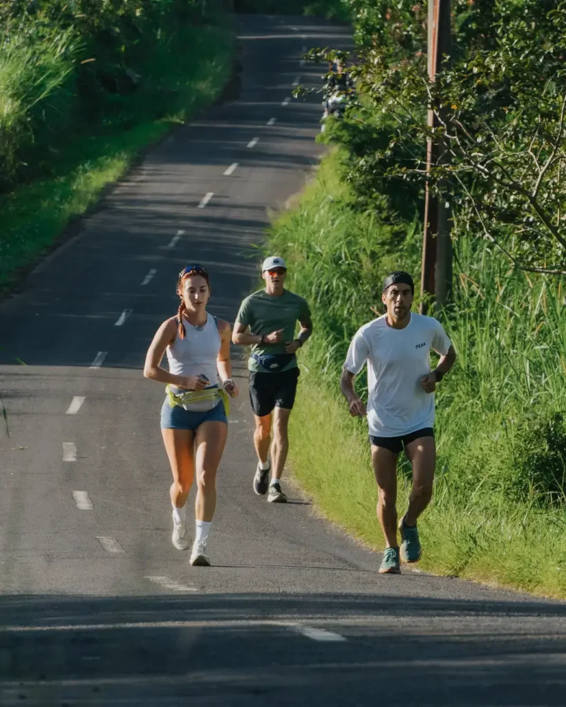 Special guest Ahmed Bedair running with two other participants up a hill during the ARC Farm Trail Run in Bali on June 15 2025.