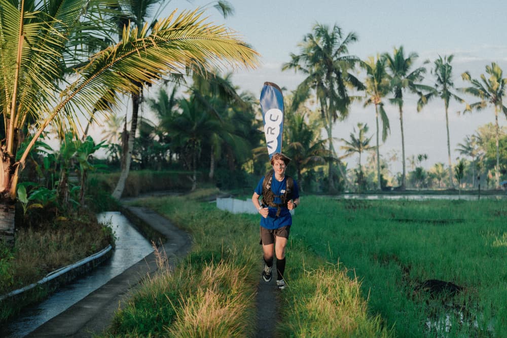 A man running through tropical rice fields during the Avenue Fitness Naturun event.